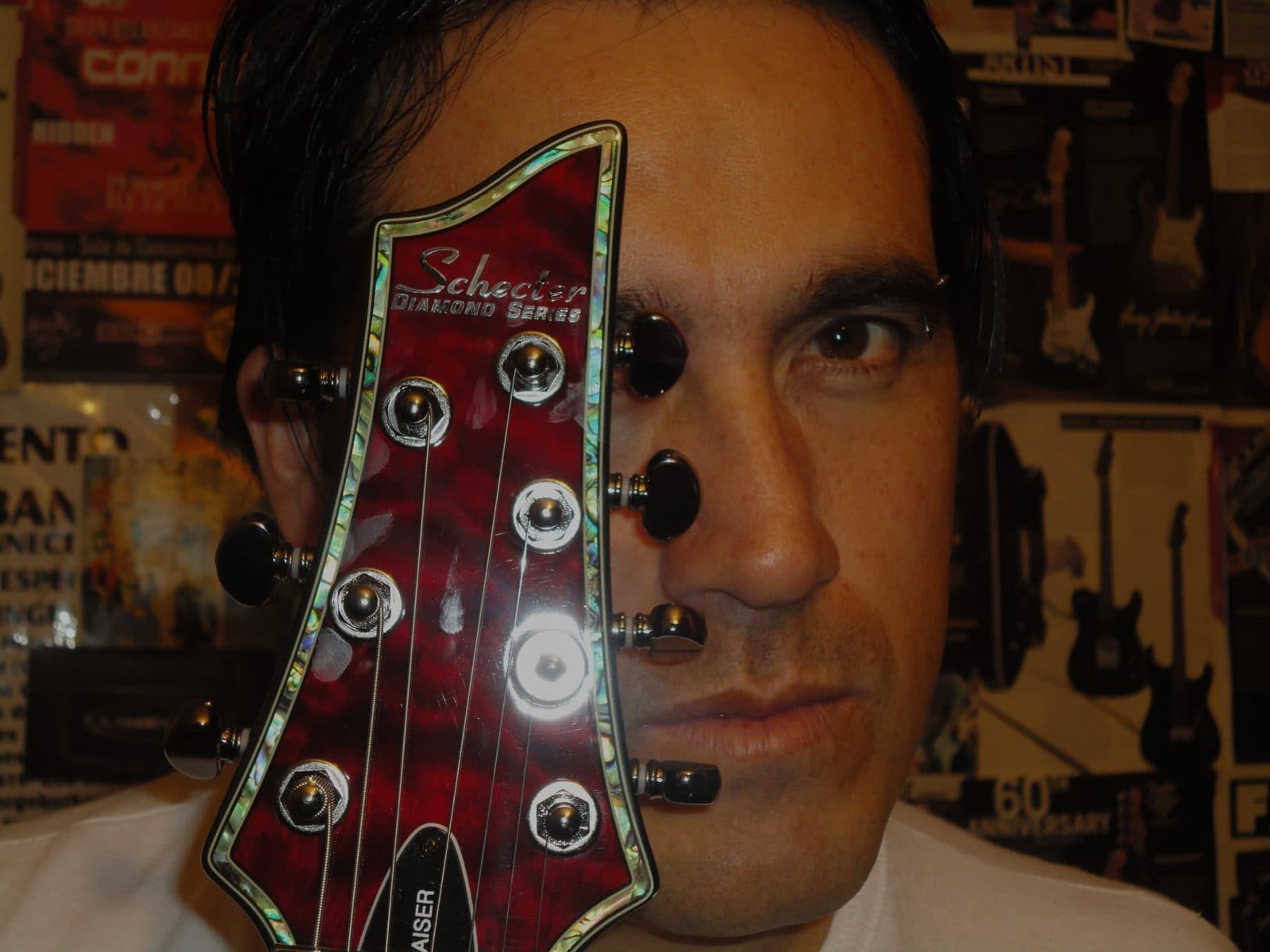 A red Schecter seven-string guitar headstock.