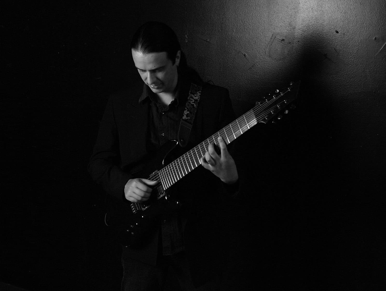 A musician playing a nine-string extended-range guitar.