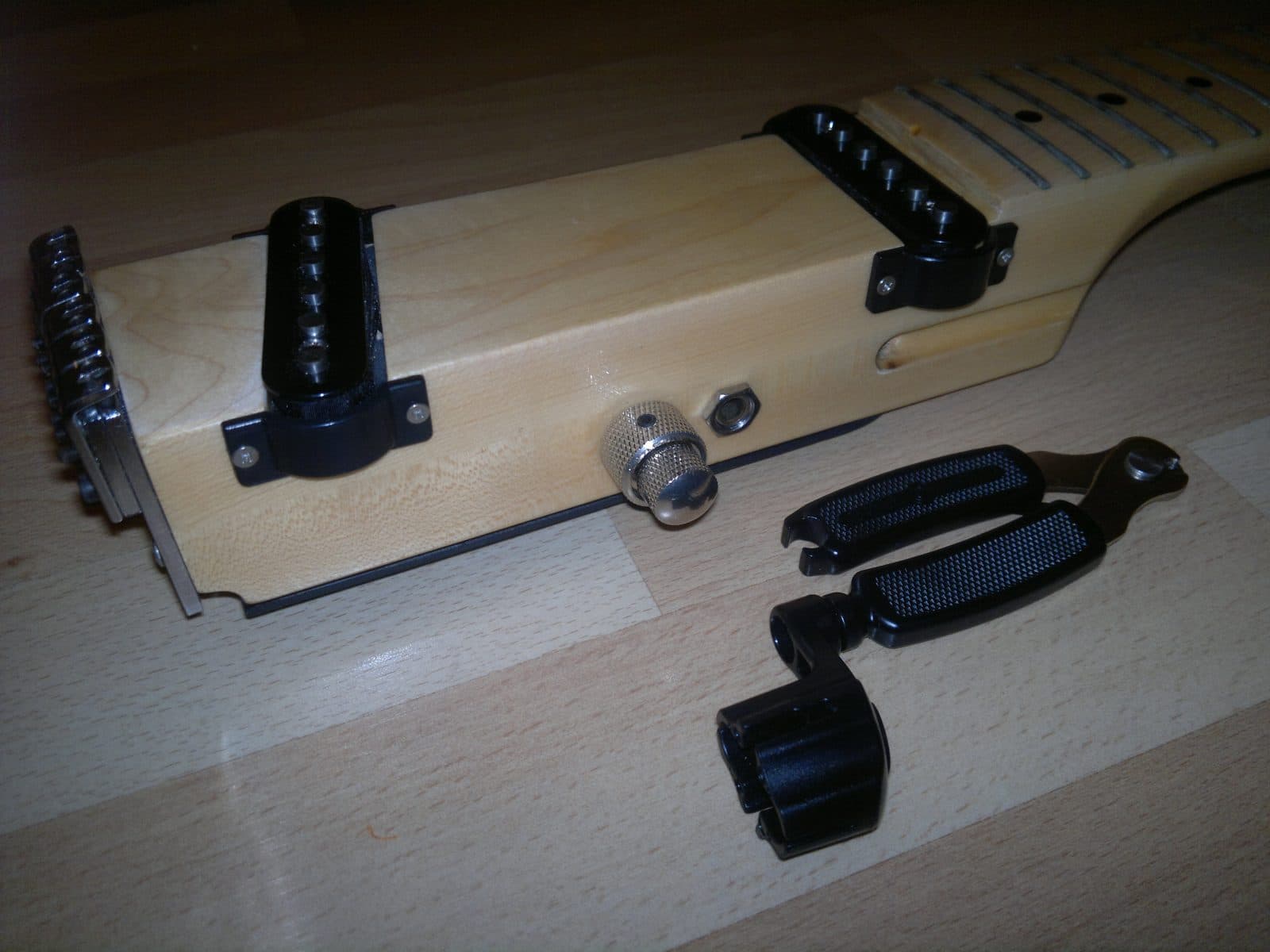 An electric guitar partially disassembled on a workbench during setup.